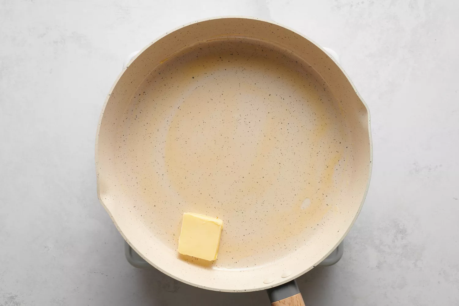 Um pedaço de manteiga em uma frigideira grande
