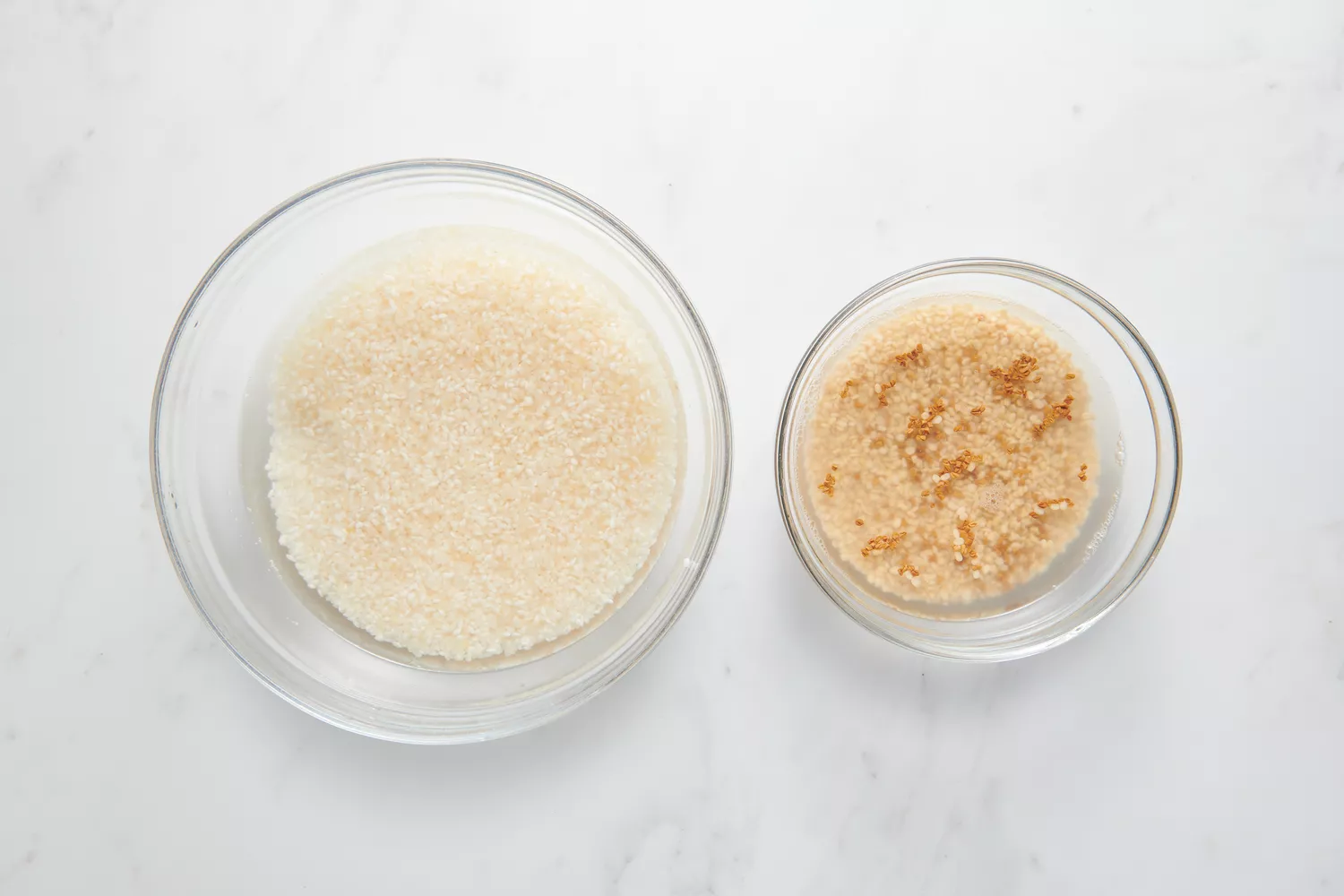 Uma tigela de Sona Masuri em água e uma tigela de urad dal e sementes de feno-grego em água