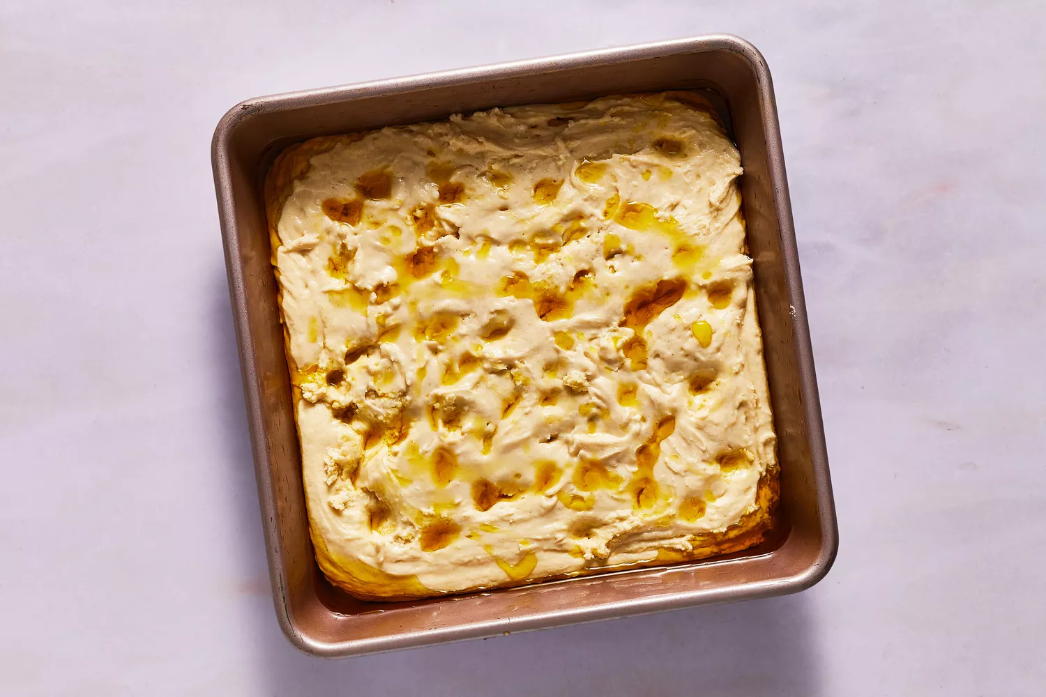 dimensões na massa de focaccia regadas com azeite antes de assar