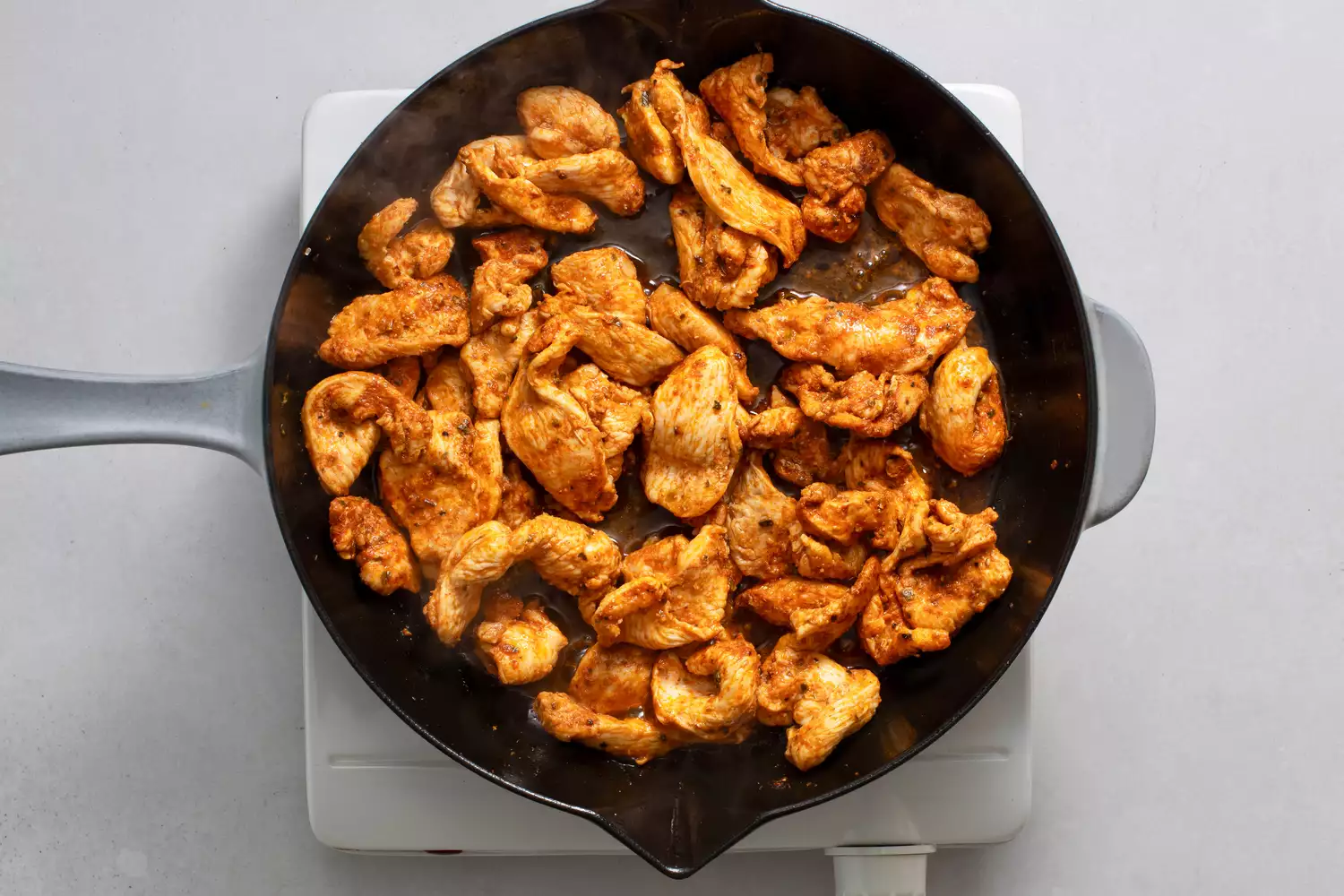 Frango cozinhando na frigideira de ferro fundido