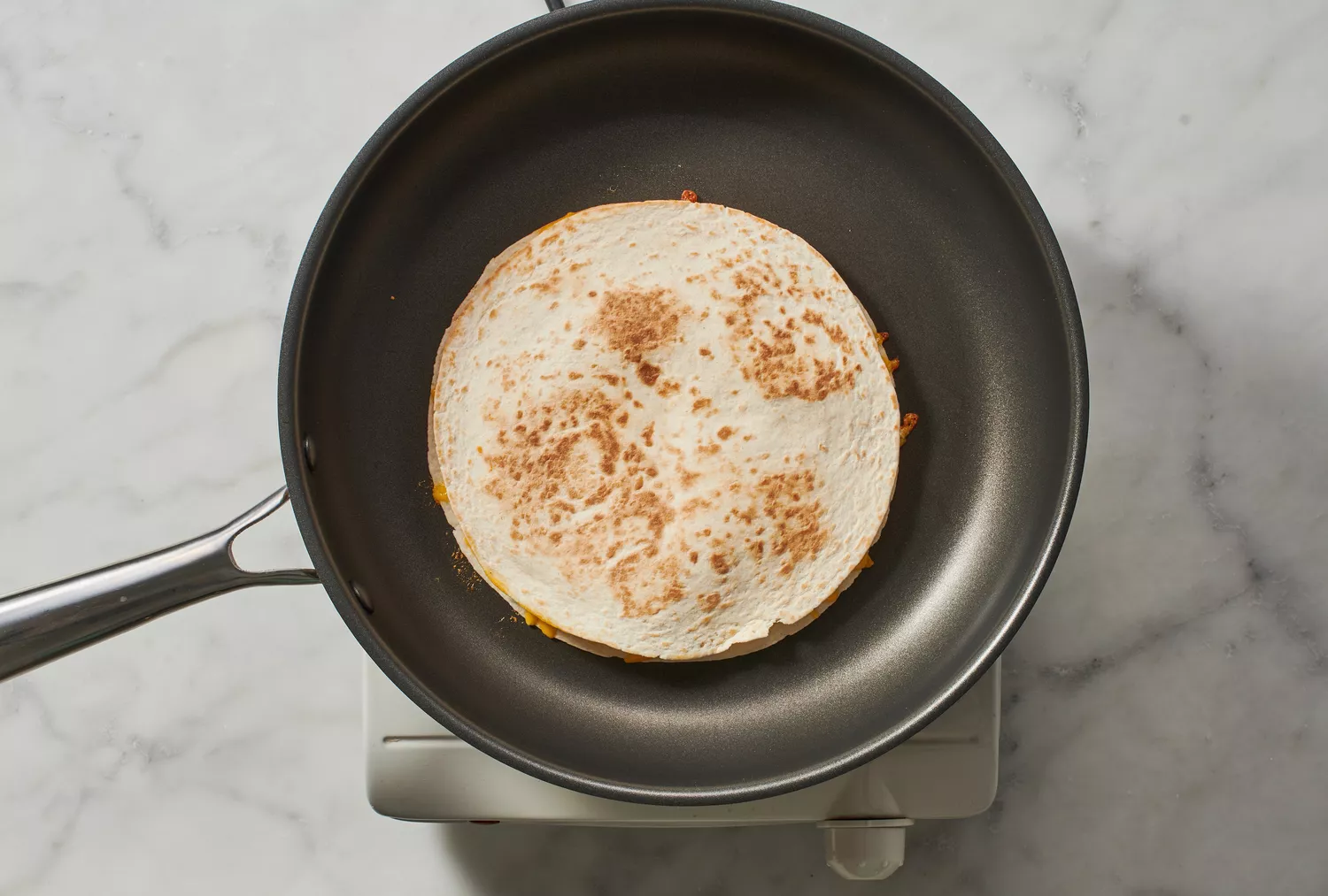 Uma quesadilla de queijo em uma frigideira