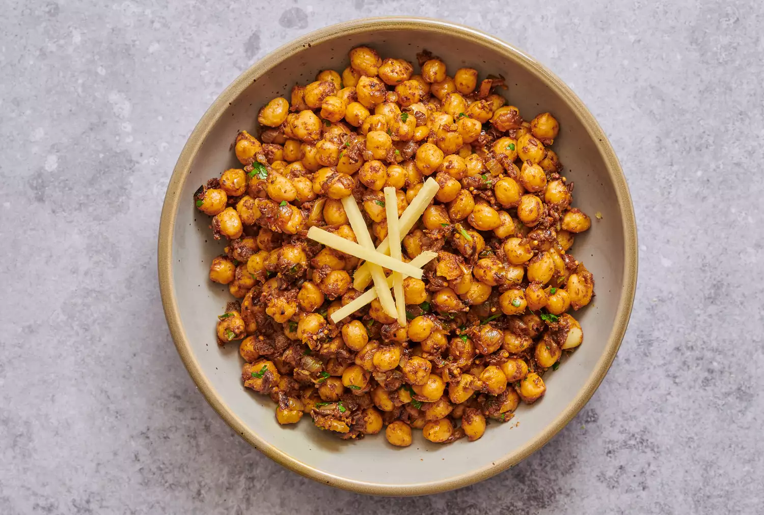 Uma tigela de chana masala decorada com gengibre em julienne