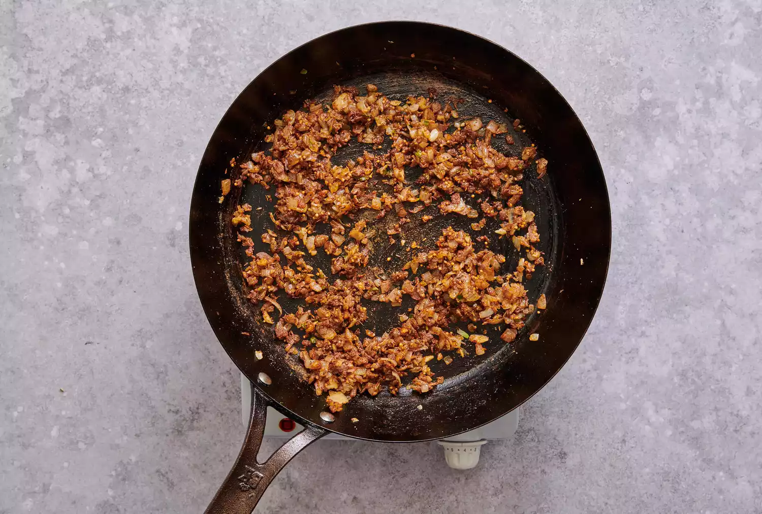 Pó de pimenta vermelha, cominho, pó de pimenta amarela, garam masala e sal adicionados à mistura