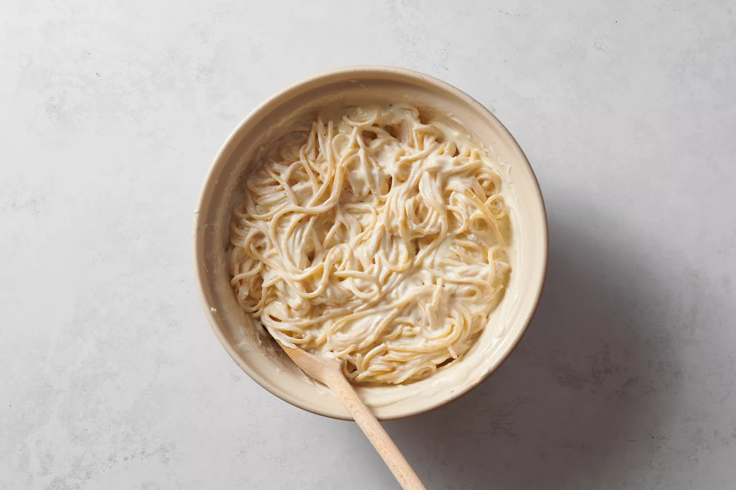 Uma tigela de espaguete envolvido em ricota, cream cheese, ovos e pimenta-do-reino