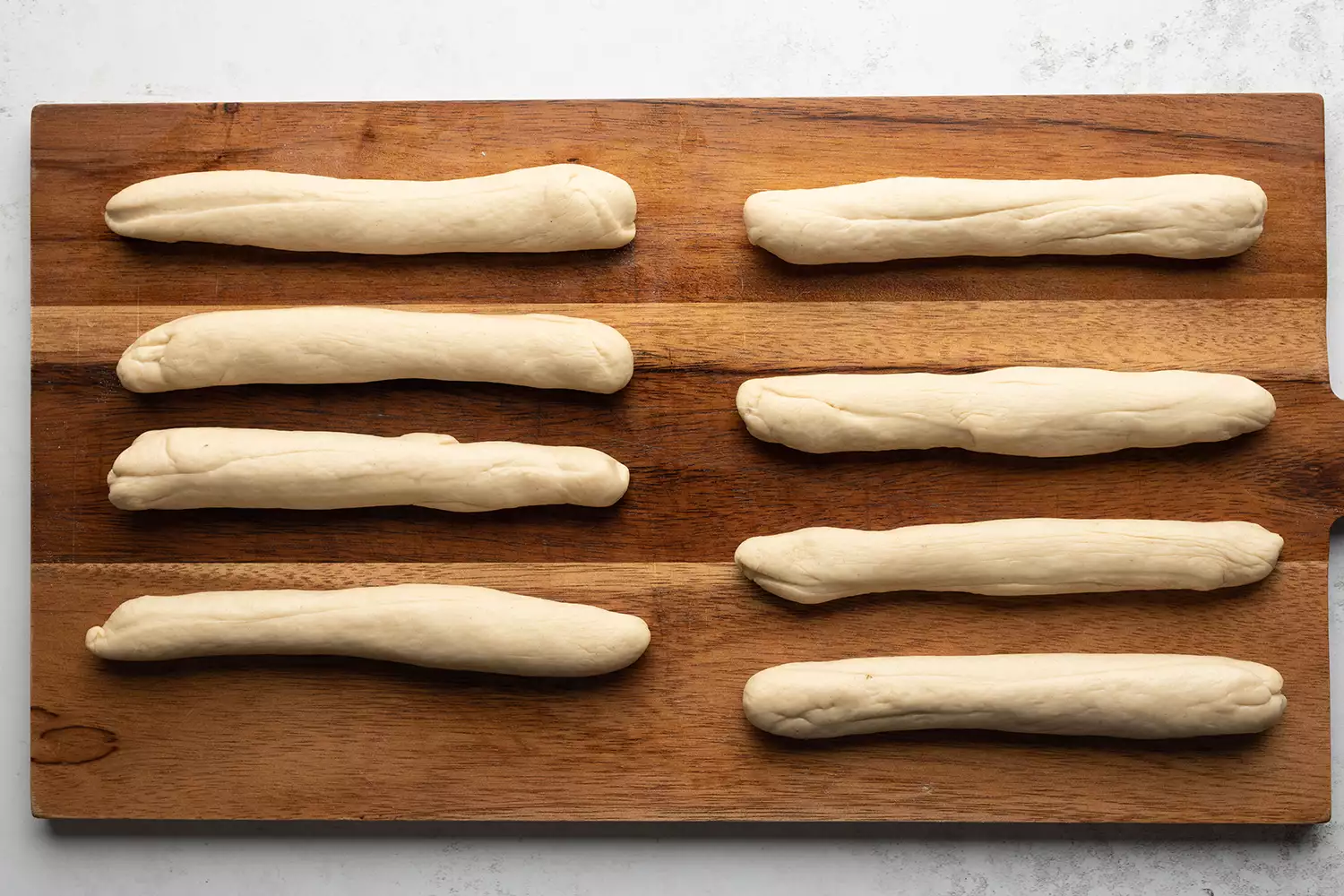 Cilindros de massa em uma tábua de madeira