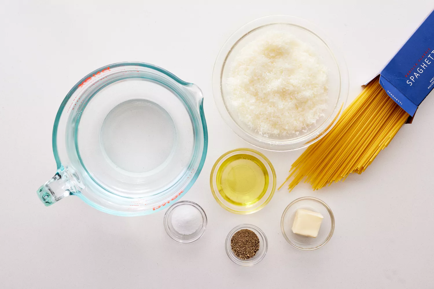 Vários recipientes cheios de ingredientes para fazer cacio-e-pepe.